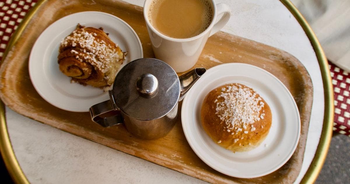 A coffee mug and pastry set on a wooden tray, a typical fika spread